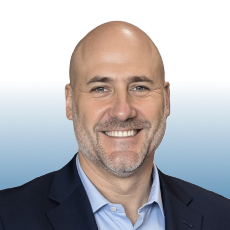 Smiling bald man in a navy blazer, Equity team member headshot
